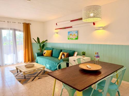 a living room with a blue couch and a table at Casa Flor de Sal Apartment in Carvoeiro