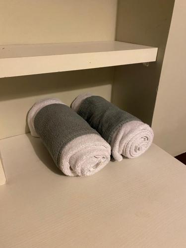 Dos toallas enrolladas en un estante en un baño. en Acogedora Habitación Doble con Baño Exclusivo, Ideal para Descanso y Tranquilidad, en Puerto Montt