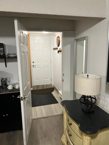 a kitchen with a door and a table with a lamp at Pau-Rae's Cozy Spot - your home away from home! in Thornhill