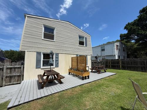 een klein huisje met twee bankjes op een terras bij Beach Happy 4bedrooms-3bath steps to beach in Virginia Beach