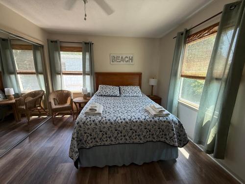 een slaapkamer met een bed, een tafel en stoelen bij Beach Happy 4bedrooms-3bath steps to beach in Virginia Beach