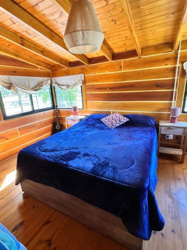 a bedroom with a bed in a wooden cabin at Cabaña para 6 personas en Calamuchita - Córdoba - "La Concepción" in Embalse Rio Tercero