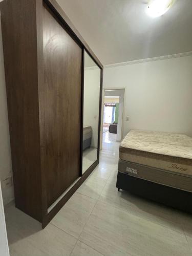 ein Schlafzimmer mit einem Bett und einem großen Spiegel in der Unterkunft Casa da lagoa in São Pedro da Aldeia