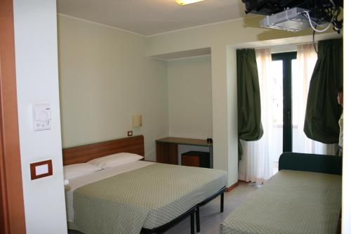 Un pat sau paturi într-o cameră la La Perla B&B Hotel