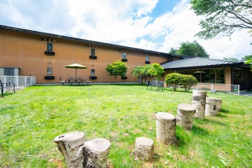 a group of tree stumps in front of a building at Sora Hotel Karuizawa Outlet in Karuizawa