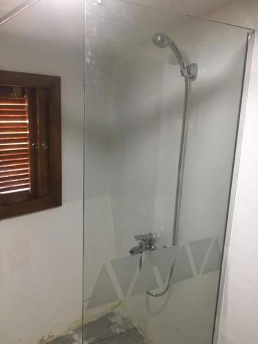 a shower with a glass door in a bathroom at Dongolah Boat Abu Simbel in Tunqālah