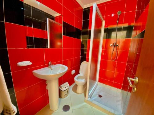 bagno rosso con lavandino e servizi igienici di African Guesthouse a Tarrafal