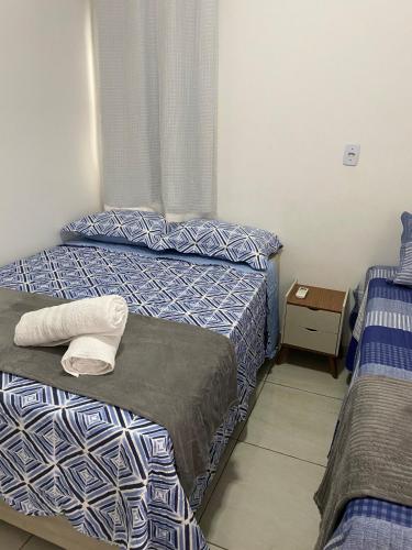 a bedroom with two beds and a night stand at Flat aconchego PNz in Petrolina