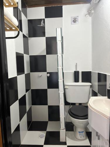 a bathroom with a black and white checkered wall at Monoambiente Noah 2 in Ezeiza
