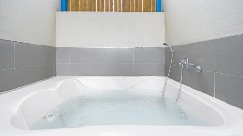 La salle de bains est pourvue d'une baignoire remplie d'eau. dans l'établissement Namhae Ourpoolvilla, à Namhae