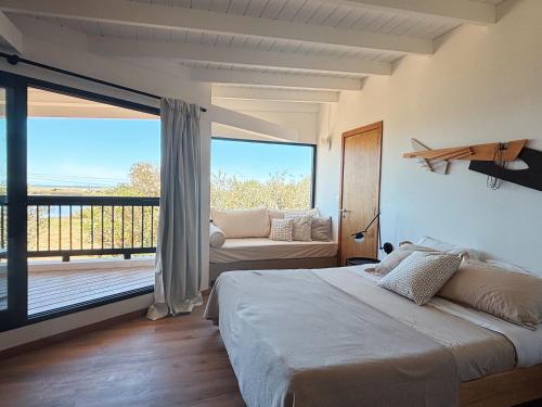 a bedroom with a large bed and a balcony at Casa Jacana in Maldonado