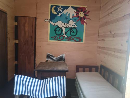 Zimmer mit einem Bett und einer Bank in einer Hütte in der Unterkunft La viuda del diablo cabañas in Punta Del Diablo