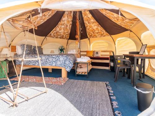 El RosarioLa Colmena Glamping Obrera的帐篷内的卧室,配有一张床和一张桌子
