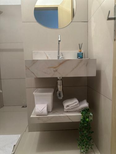 a bathroom with a sink and a mirror at E Lindo Sobrado com 2 quartos em condomínio - Centro in Marília
