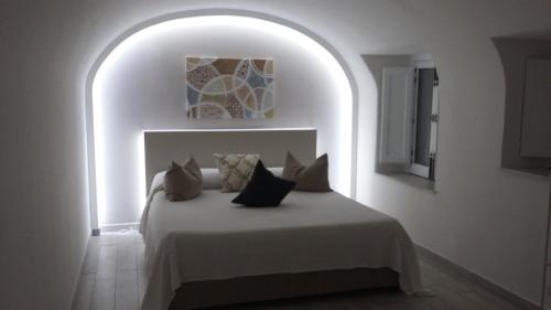 een witte slaapkamer met een bed met kussens erop bij Casa Umberto I in Catania