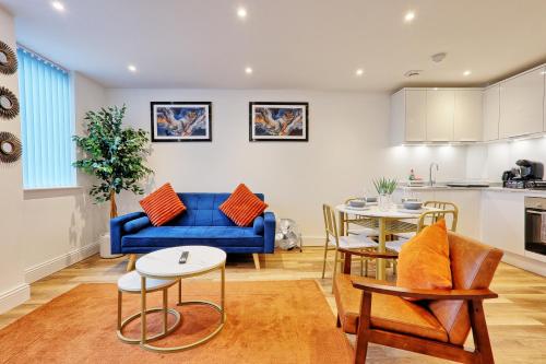 a living room with a blue couch and a table at Luxuriously Cosy 1 Bed Flat at Trinity Point Gravesend, Suitable for Long Stay and Short Stay in Gravesend