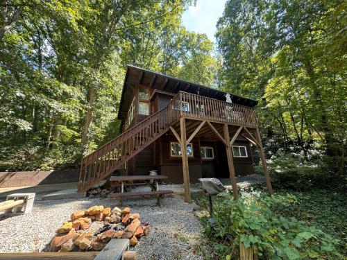 Una cabaña en el bosque con una mesa de picnic y una chimenea. en Elk Ridge - cherokee casino GSMNP, en Whittier