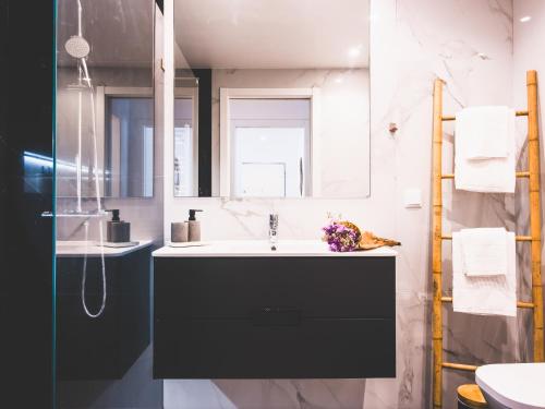 a bathroom with a sink and a mirror at Moodhu Villa - Cozy Apart w/ Amazing Terrace in Leiria