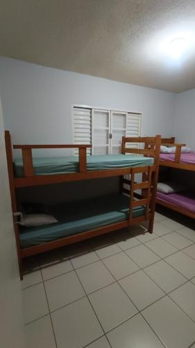 a room with two bunk beds and a table at Casatemporadapadilha in Olímpia