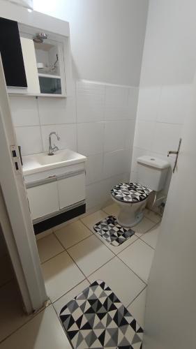 a small bathroom with a toilet and a sink at Casatemporadapadilha in Olímpia