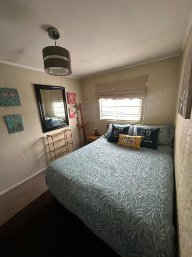 a bedroom with a bed with a blue comforter at La casa de Belén in Valdivia