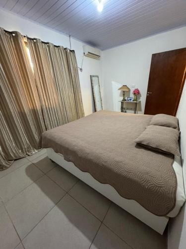 a bedroom with a large bed and a window at Casa Aconchego da Vó Gera in Foz do Iguaçu