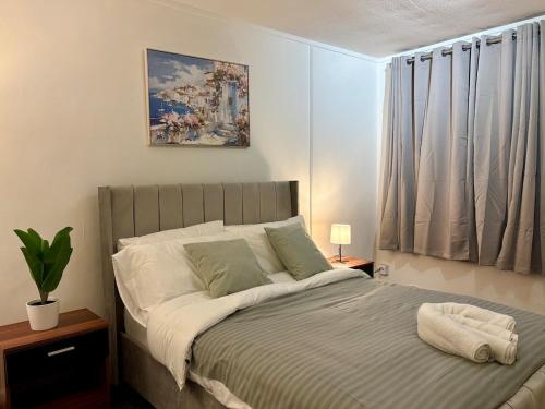 a bedroom with a bed with a painting on the wall at Bright and Spacious 2 Bed Flat Sleeps 5 in Nottingham