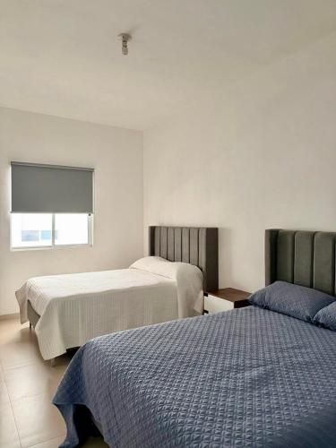 een slaapkamer met twee bedden en een raam bij Moderna Casa Céntrica in Monterrey