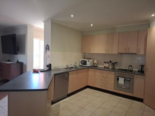 a kitchen with wooden cabinets and a counter top at Annesley Central in Echuca