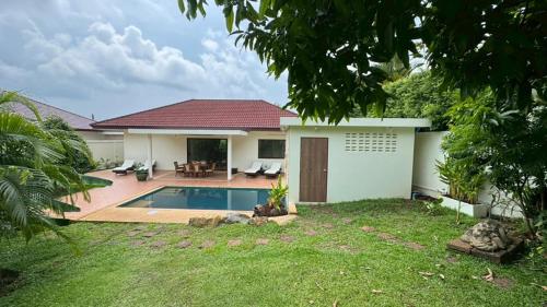 een huis met een zwembad in de tuin bij Lai Thai Villa 4 in Rawai Beach