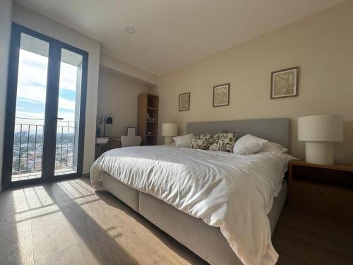 una camera da letto con un letto grande e una grande finestra di Depa - Estadio Guadalajara - Ciudad Judicial a Guadalajara