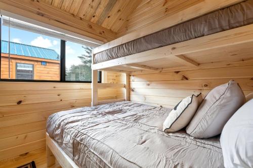 a bedroom with a bed in a wooden cabin at Cozy ski cabin #3, 3 beds in Bethel