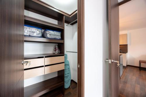 a room with a closet with wooden shelves and a door at Apartamentos Casa Grande in Rionegro