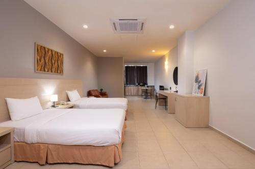 een hotelkamer met twee bedden en een bureau bij Golden View Serviced Apartments in George Town