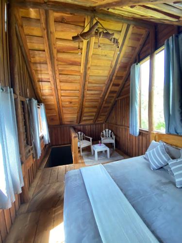 a bedroom with a large bed in a wooden room at Cabana Rústica em Piedade in Piedade