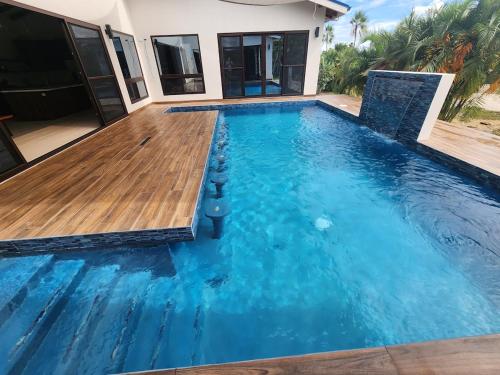ein Swimmingpool mit Holzterrasse in einer Villa in der Unterkunft Sunset Oasis Waterfront in Maya Beach