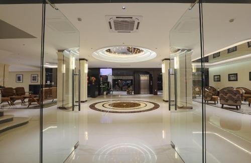 a room with glass walls and a lobby with a rug at Huong Giang Hotel Resort & Spa in Hue