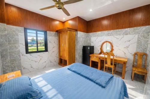 een slaapkamer met een bed, een bureau en een raam bij Bình Minh Hotel Bình Dương in Xóm Bưng