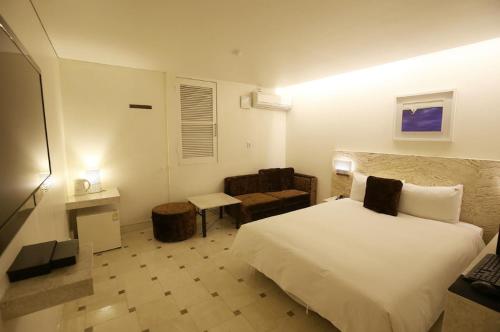 a bedroom with a large white bed and a chair at 청주 호텔 린 in P'ungnyŏn-gol