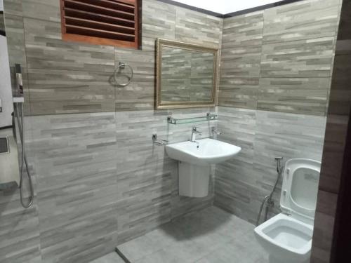 een badkamer met een wastafel, een urinoir en een toilet bij Stream Inn Haputale in Haputale