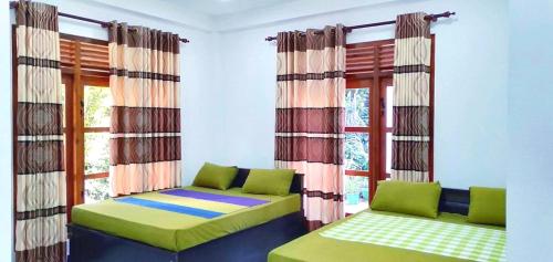 een woonkamer met 2 bedden en een raam bij Stream Inn Haputale in Haputale