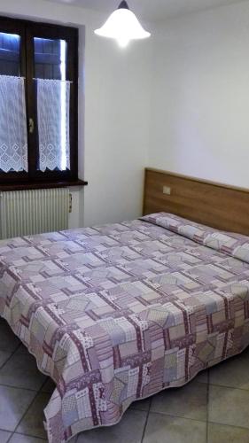 a bedroom with a bed in a room with a window at Pinzolocasa in Pinzolo