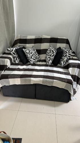 eine Couch mit Kissen auf dem Boden in einem Zimmer in der Unterkunft Casa térrea 2 suítes condomínio in Lauro de Freitas