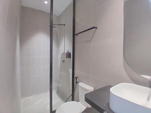 ein weißes Badezimmer mit Dusche und Toilette in der Unterkunft Cibulan Indah Hotel in Brujul