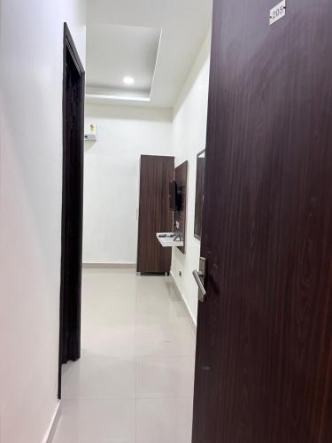 einen Flur mit Holztür und ein Badezimmer in der Unterkunft Hotel heaven inn in Amritsar