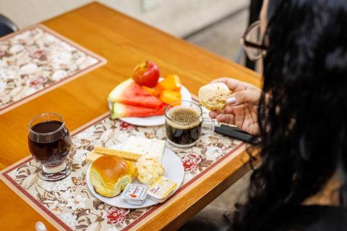 una persona seduta a un tavolo con un piatto di cibo di Hotel Move BH a Belo Horizonte