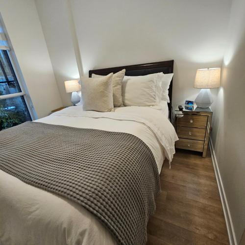 ein Schlafzimmer mit einem großen Bett und zwei Lampen in der Unterkunft Stockyards in Toronto