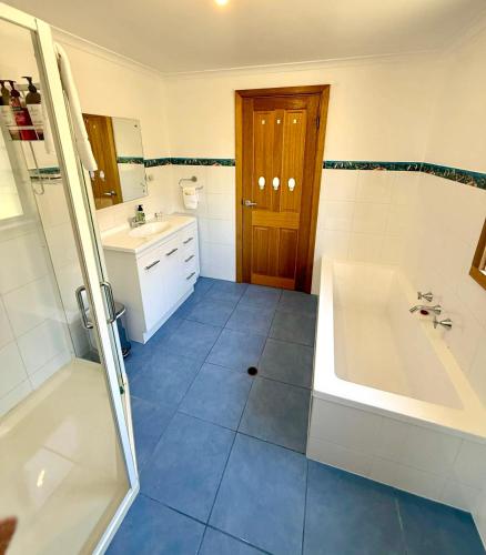 a bathroom with a tub and a sink at Bayview Heights in Kingscote