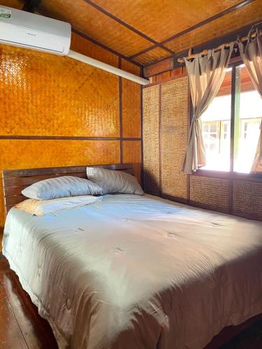 a bedroom with a large bed with a window at Chill House kohchang in Ban Bang Bao