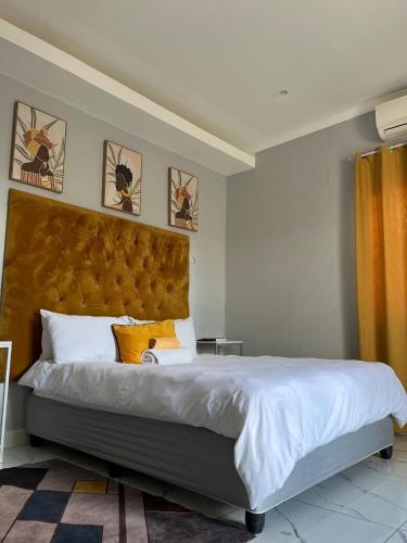 a bedroom with a large bed with a large headboard at Red Hills Guesthouse in Tsumeb